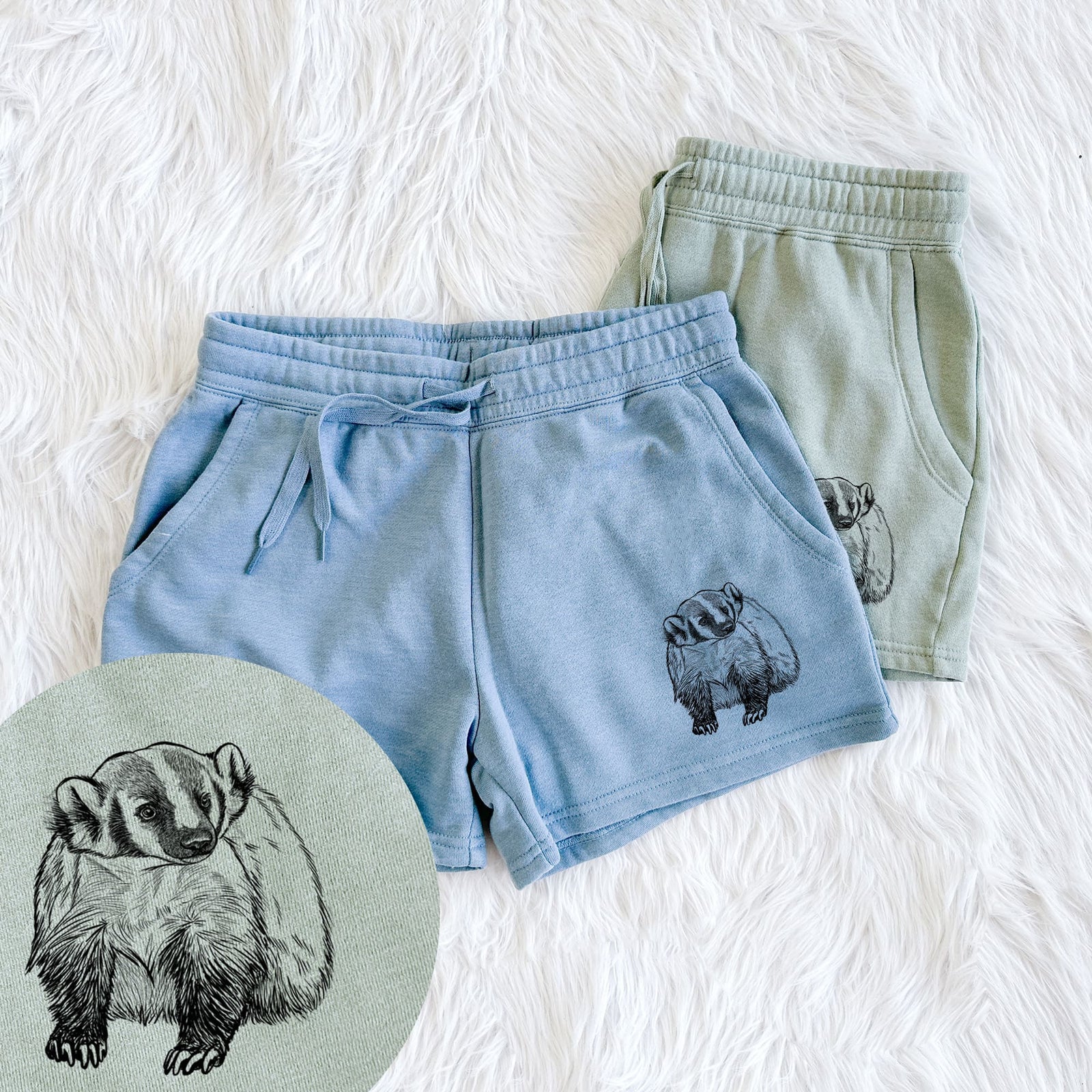 Two pairs of Cali Wave shorts in different colors printed with a detailed black ink illustration of an American badger facing forward, with a close-up of the print.