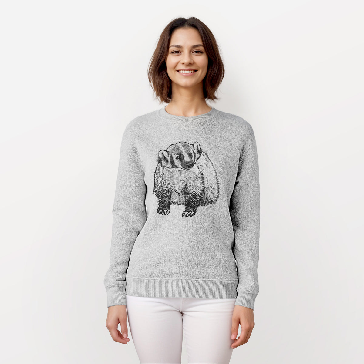 Woman wearing a knit sweatshirt printed with a detailed black ink illustration of an American badger facing forward.