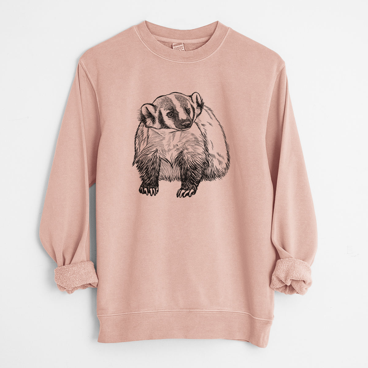 Dusty pink pigment dyed crewneck sweatshirt laid flat with the sleeves rolled, printed with a detailed black ink illustration of an American badger facing forward.