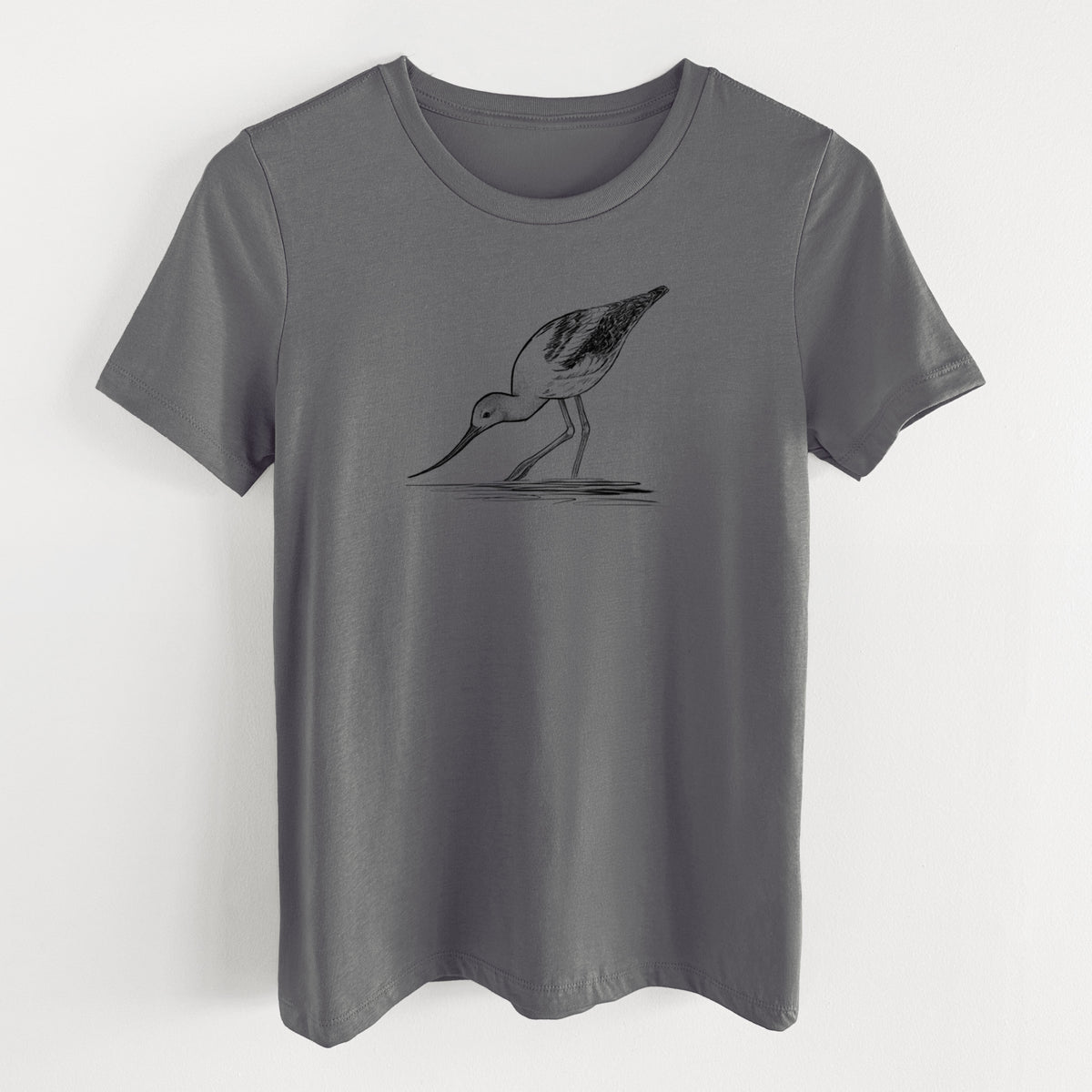Asphalt women's relaxed fit cotton t-shirt laid flat, printed with a detailed black ink sketch of an American avocet wading in shallow water.