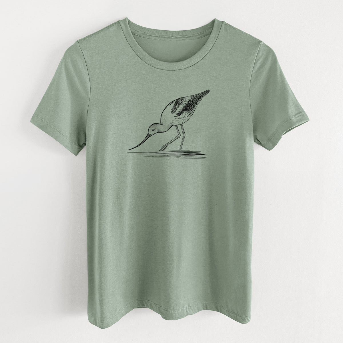 Sage green women's relaxed fit cotton t-shirt laid flat, printed with a detailed black ink sketch of an American avocet wading in shallow water.