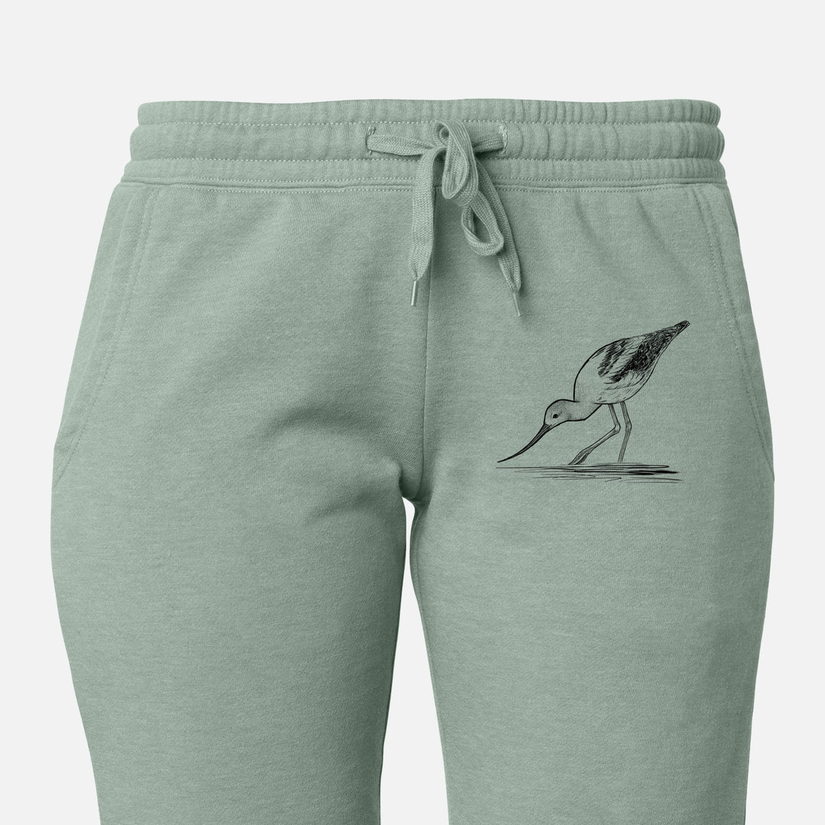 Front of sage green Cali Wave sweatpants, printed with a detailed black ink sketch of an American avocet wading in shallow water on the leg.