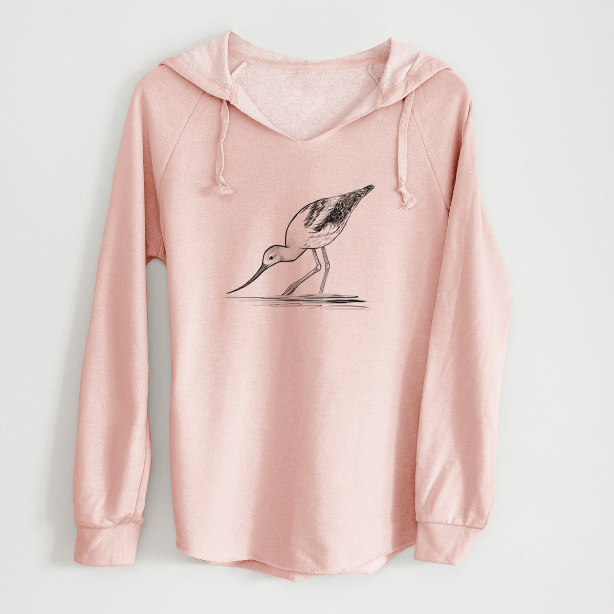 Blush pink women's Cali Wave hooded sweatshirt laid flat, printed with a detailed black ink sketch of an American avocet wading in shallow water.