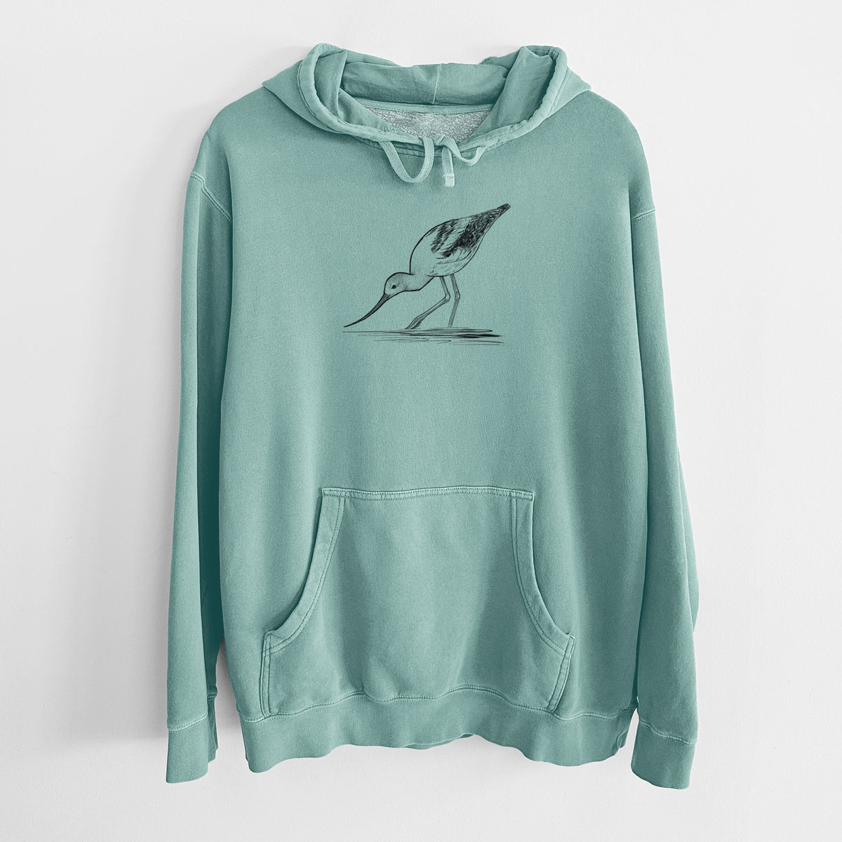 Mint green pigment dyed hoodie laid flat, printed with a detailed black ink sketch of an American avocet wading in shallow water.