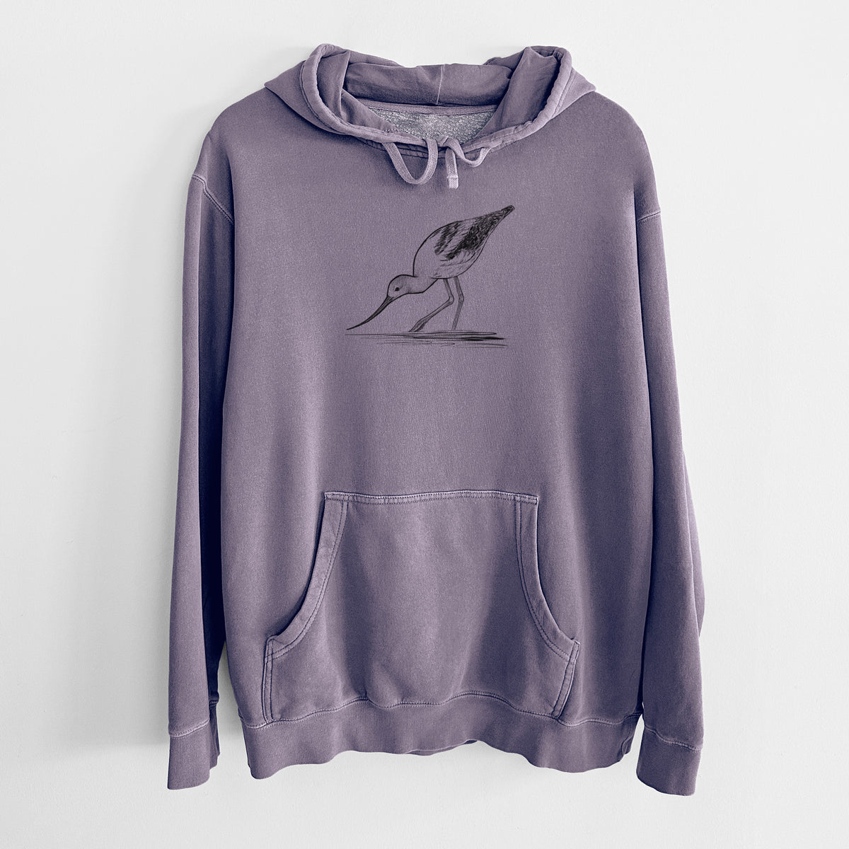 Plum purple pigment dyed hoodie laid flat, printed with a detailed black ink sketch of an American avocet wading in shallow water.