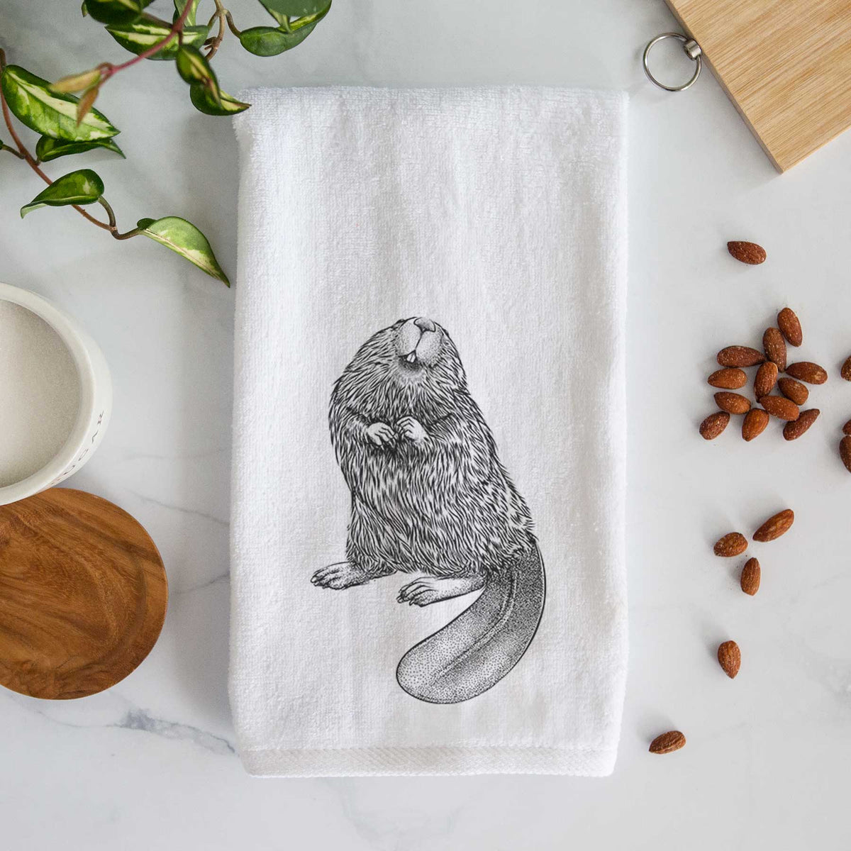 White hand towel printed with a detailed black ink illustration of an American beaver sitting upright with its flat tail.