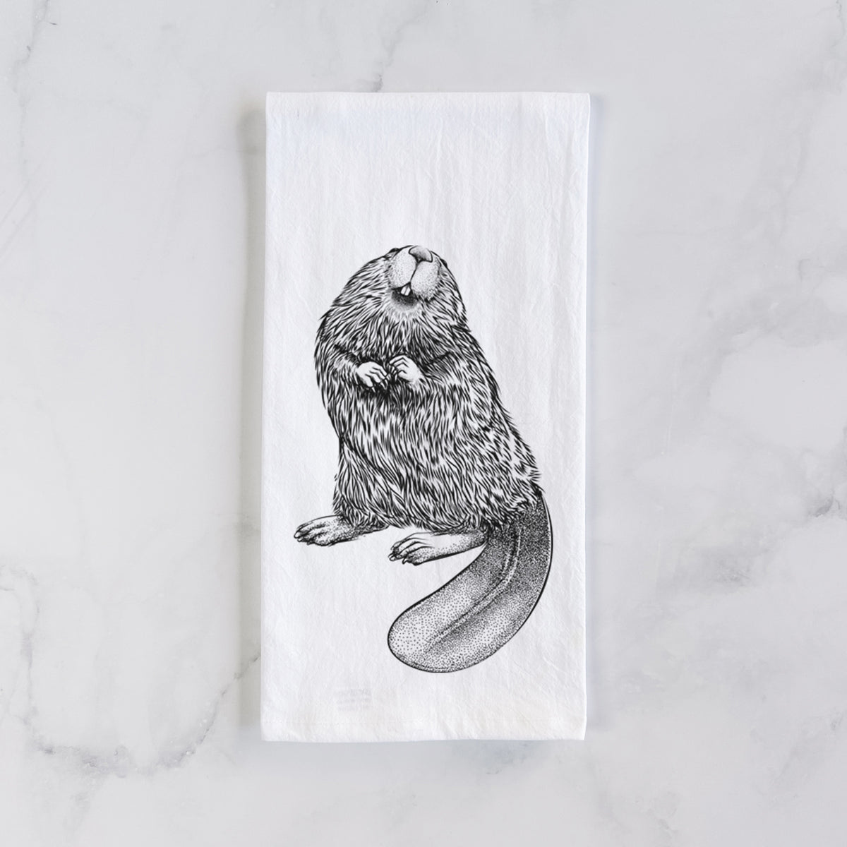 White cotton tea towel laid flat on marble, printed with a detailed black ink illustration of an American beaver sitting upright with its flat tail.