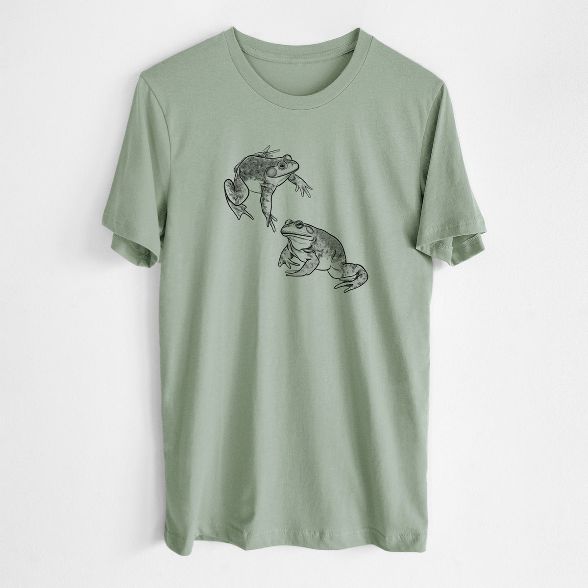 Sage green lightweight cotton t-shirt laid flat, printed with a detailed black ink illustration of two American bullfrogs.