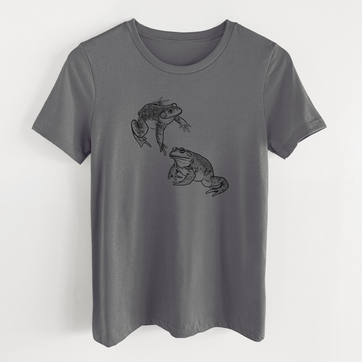 Asphalt women's relaxed fit cotton t-shirt laid flat, printed with a detailed black ink illustration of two American bullfrogs.