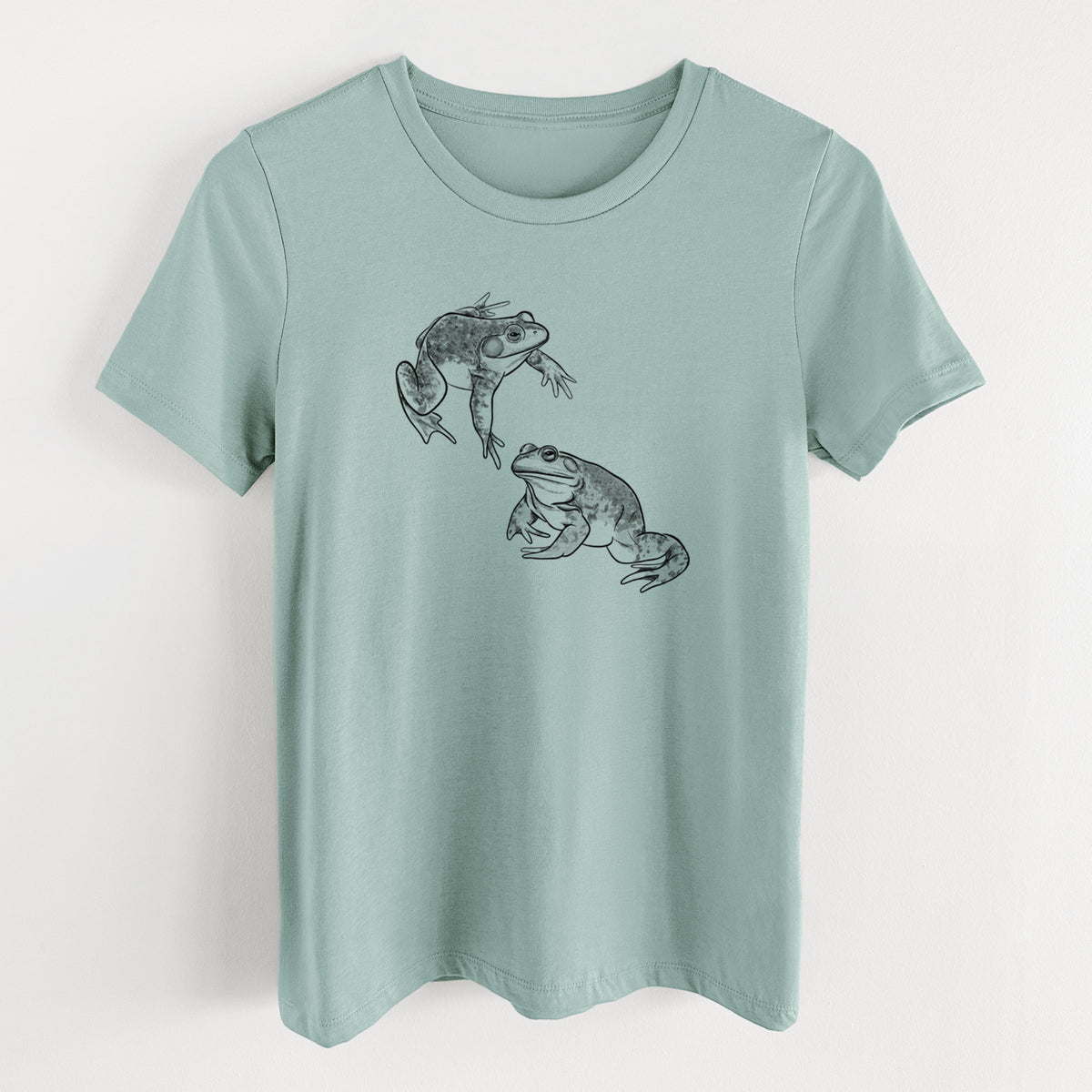Dusty blue women's relaxed fit cotton t-shirt laid flat, printed with a detailed black ink illustration of two American bullfrogs.