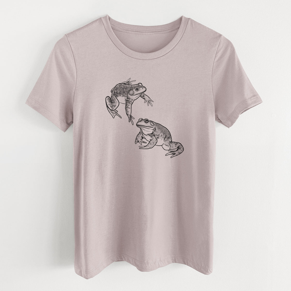 Pink gravel women's relaxed fit cotton t-shirt laid flat, printed with a detailed black ink illustration of two American bullfrogs.