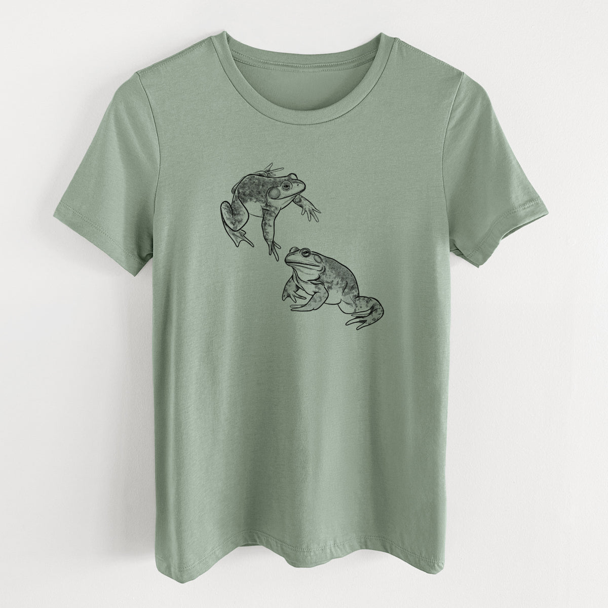 Sage green women's relaxed fit cotton t-shirt laid flat, printed with a detailed black ink illustration of two American bullfrogs.
