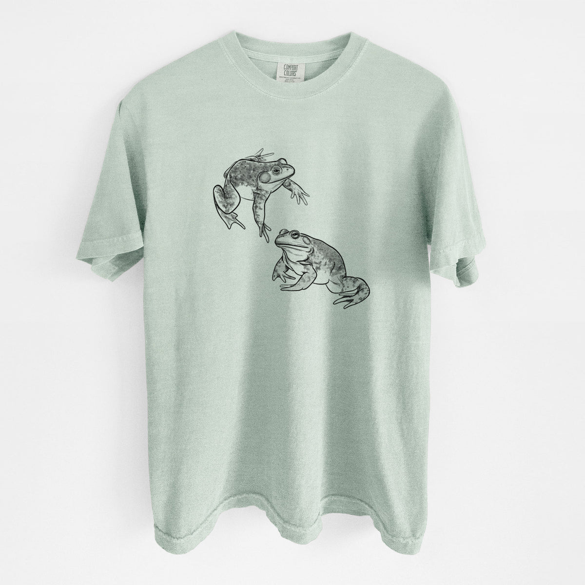 Bay green Comfort Colors t-shirt laid flat, printed with a detailed black ink illustration of two American bullfrogs.