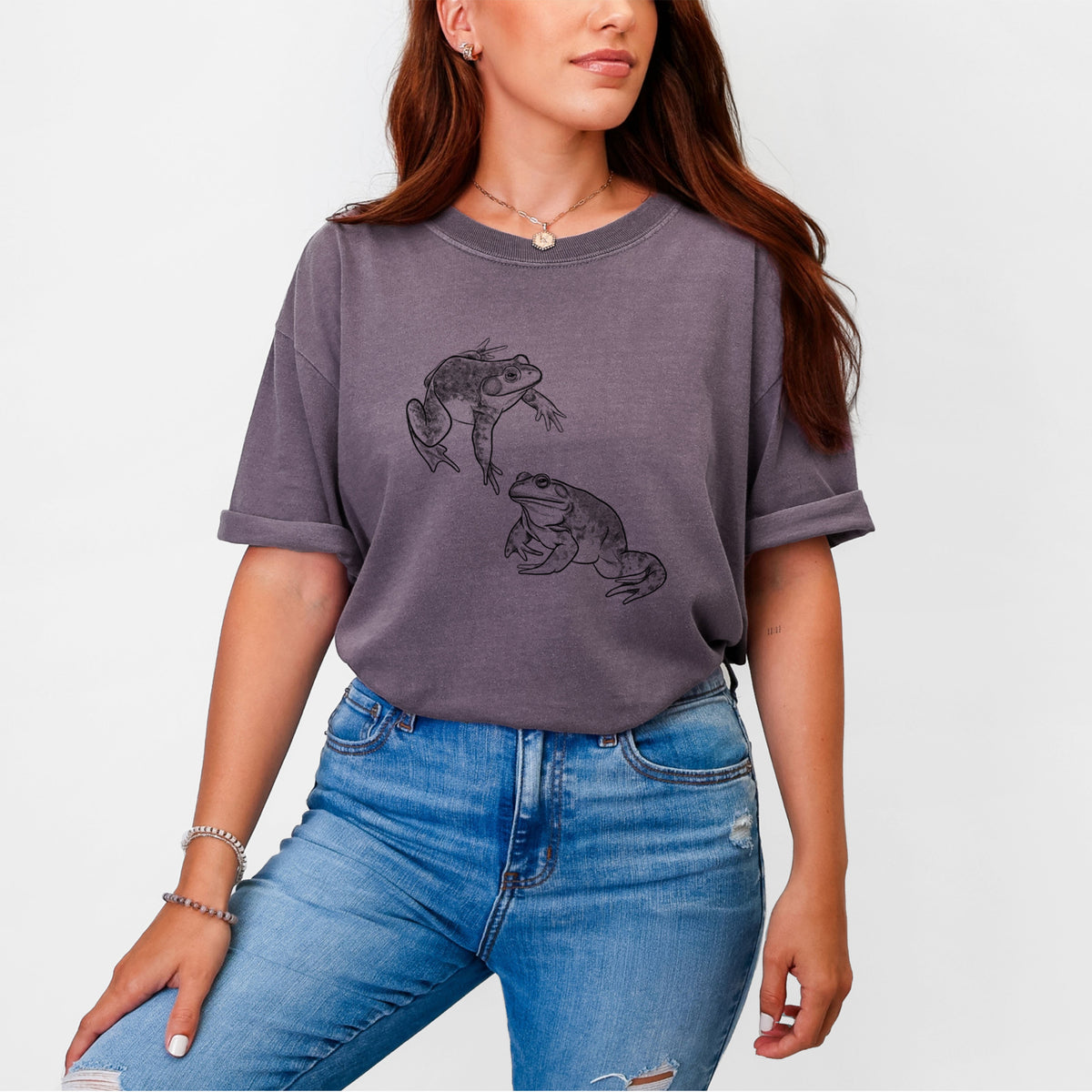Woman wearing a Comfort Colors t-shirt printed with a detailed black ink illustration of two American bullfrogs.