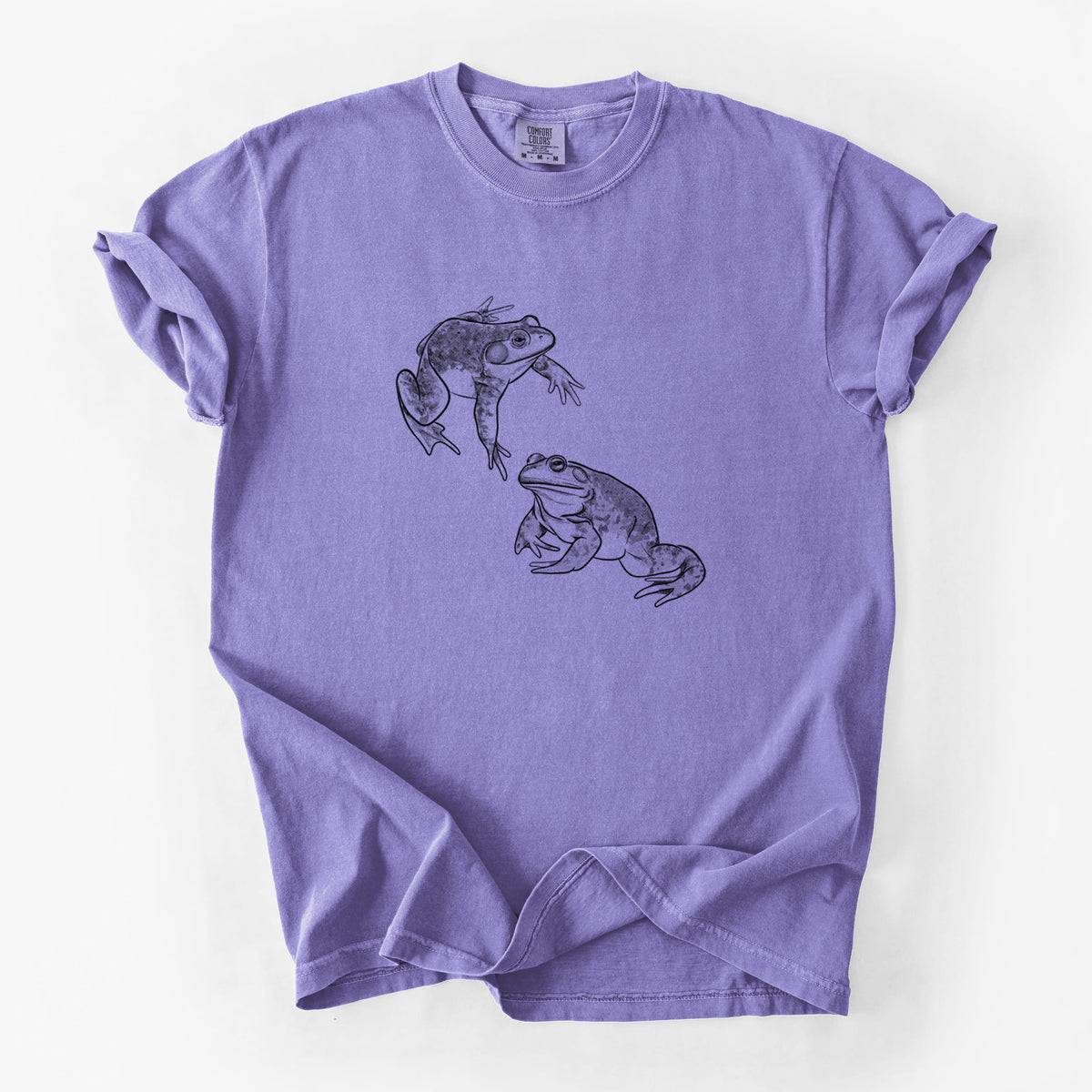 Violet purple Comfort Colors t-shirt laid flat, printed with a detailed black ink illustration of two American bullfrogs.