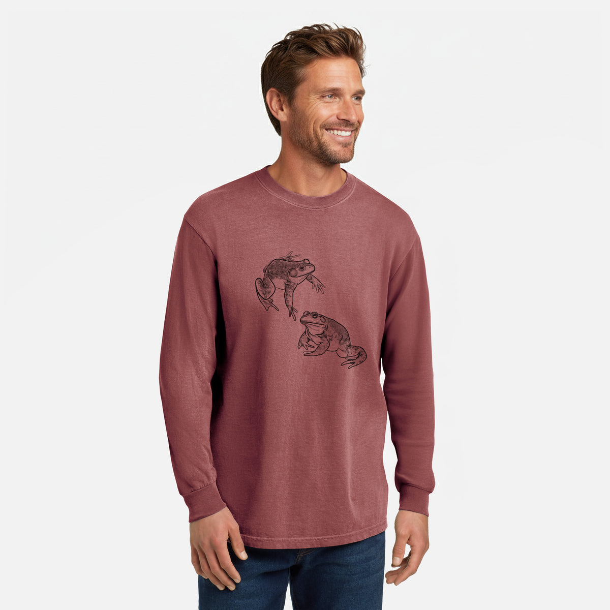 Brick red Comfort Colors long sleeve shirt printed with a detailed black ink illustration of two American bullfrogs, shown in a lifestyle photo.