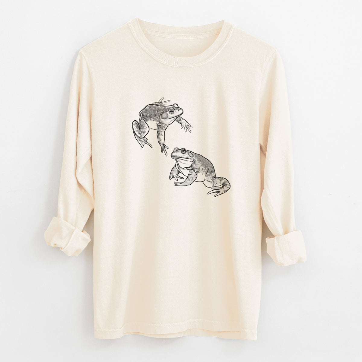 Ivory Comfort Colors long sleeve shirt laid flat with the cuffs rolled, printed with a detailed black ink illustration of two American bullfrogs.