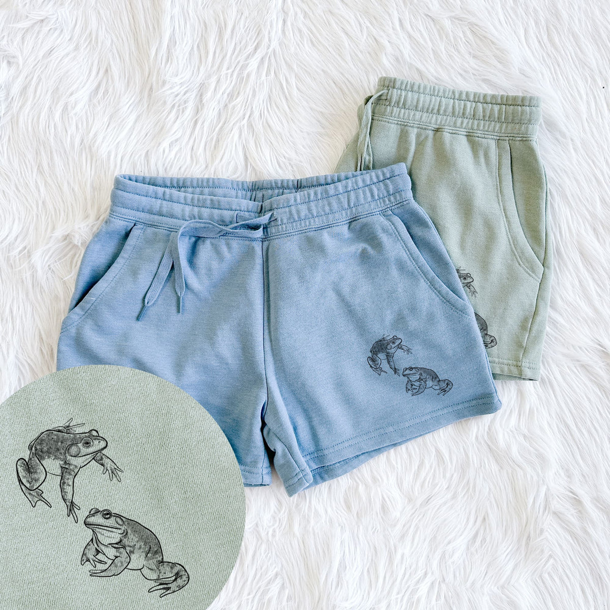 Two pairs of Cali Wave shorts in different colors printed with a detailed black ink illustration of two American bullfrogs, with a close-up of the print.