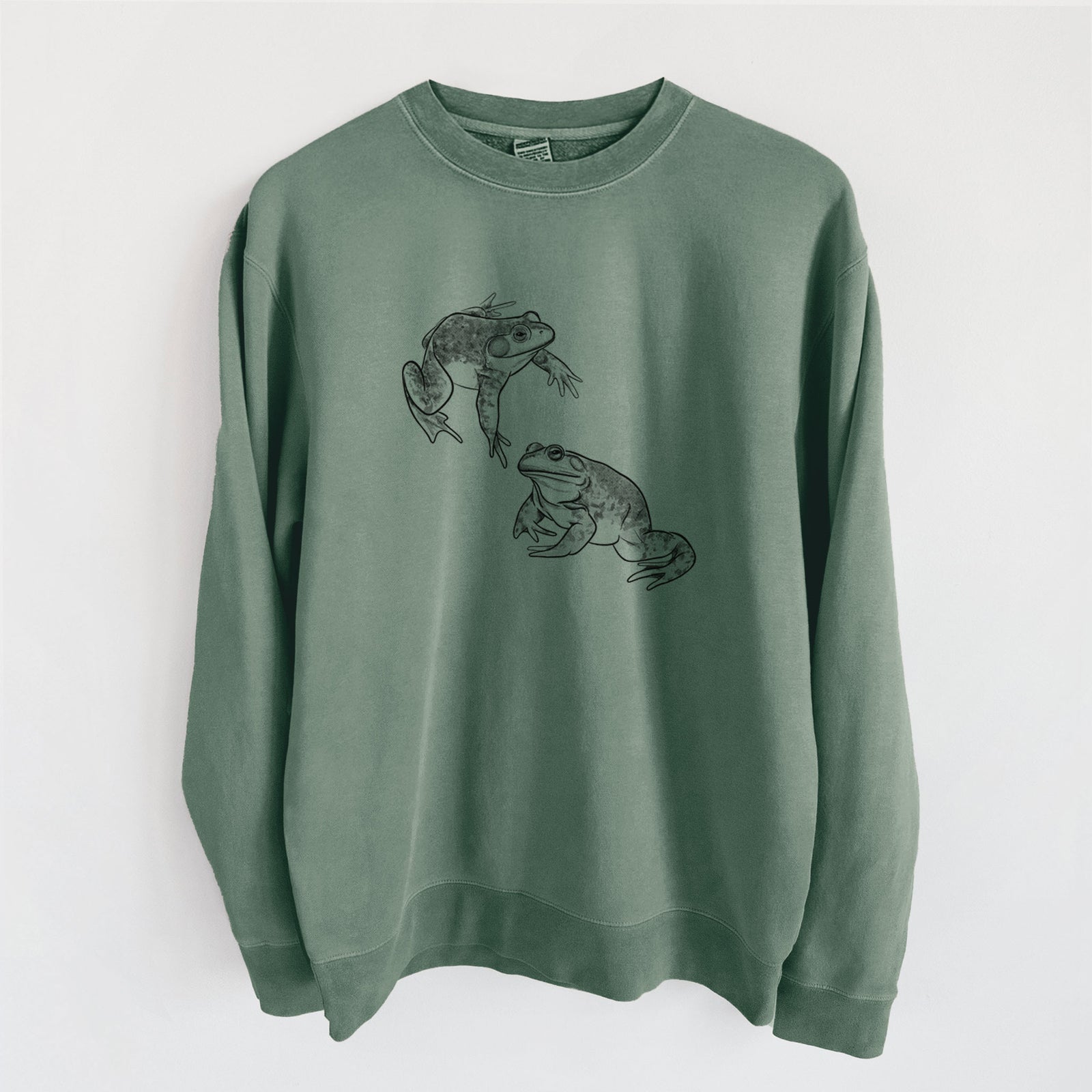 Alpine green pigment dyed crewneck sweatshirt laid flat, printed with a detailed black ink illustration of two American bullfrogs.