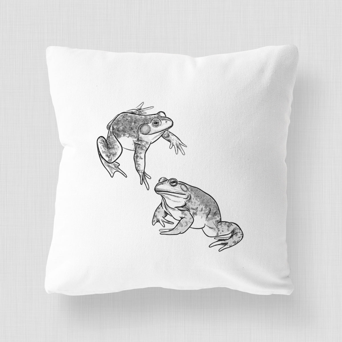 White pillow cover printed with a detailed black ink illustration of two American bullfrogs.