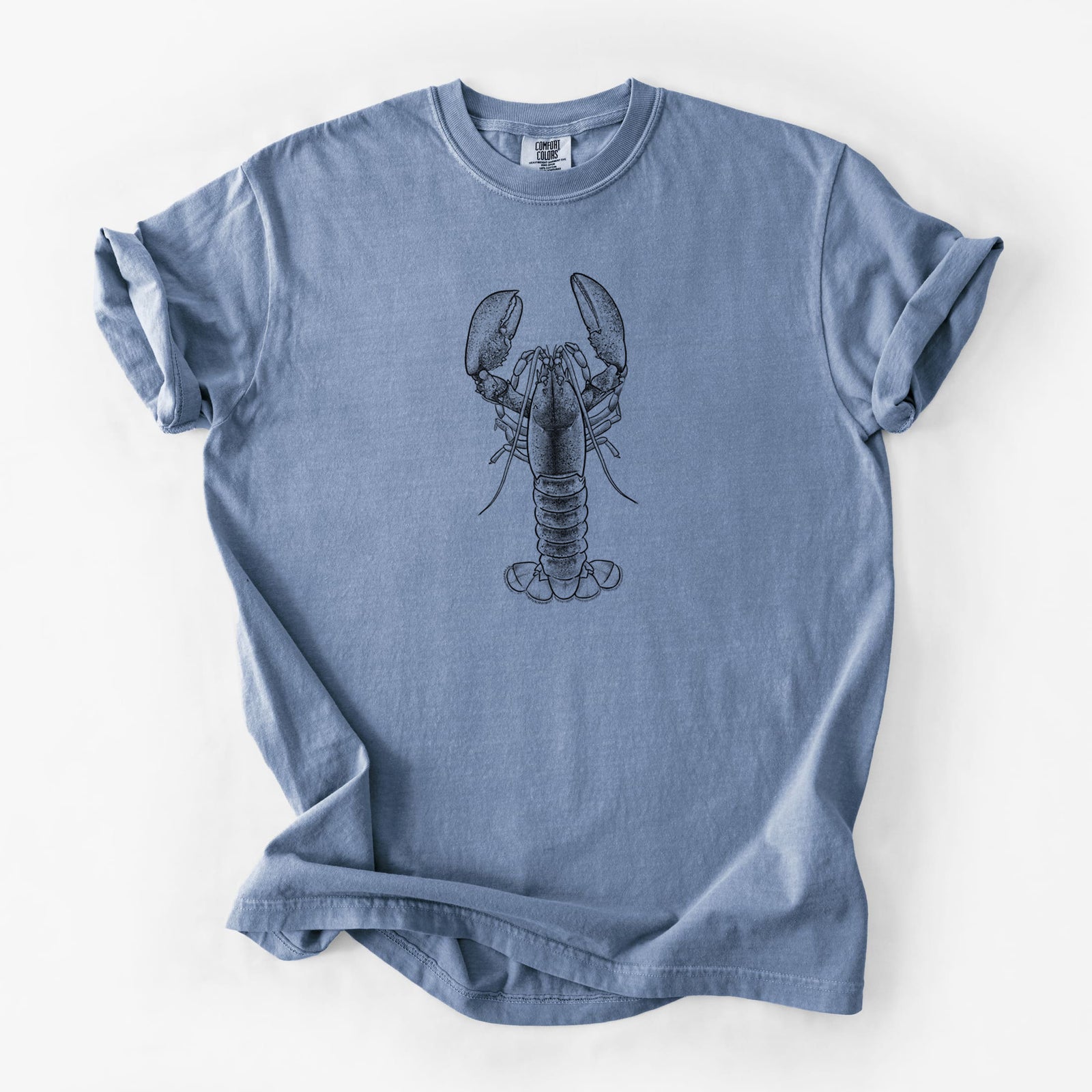 Blue jean Comfort Colors t-shirt laid flat, printed with a detailed black ink illustration of an American lobster with its claws raised, seen from above.