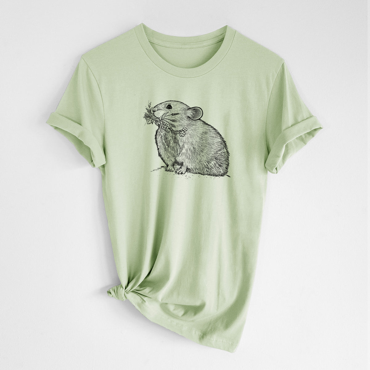 Spring green lightweight cotton t-shirt laid flat with the sleeves rolled, printed with a detailed black ink illustration of an American pika holding flowers and grass in its mouth.