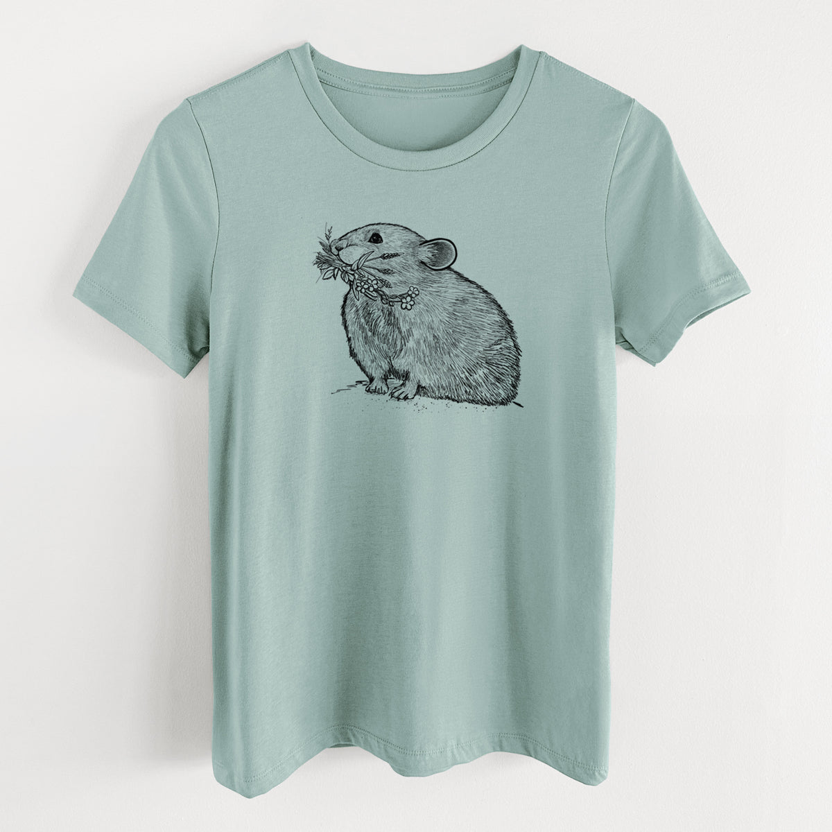 Dusty blue women's relaxed fit cotton t-shirt laid flat, printed with a detailed black ink illustration of an American pika holding flowers and grass in its mouth.