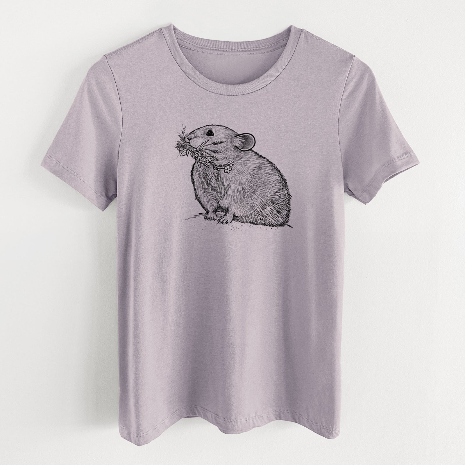 Light violet women's relaxed fit cotton t-shirt laid flat, printed with a detailed black ink illustration of an American pika holding flowers and grass in its mouth.