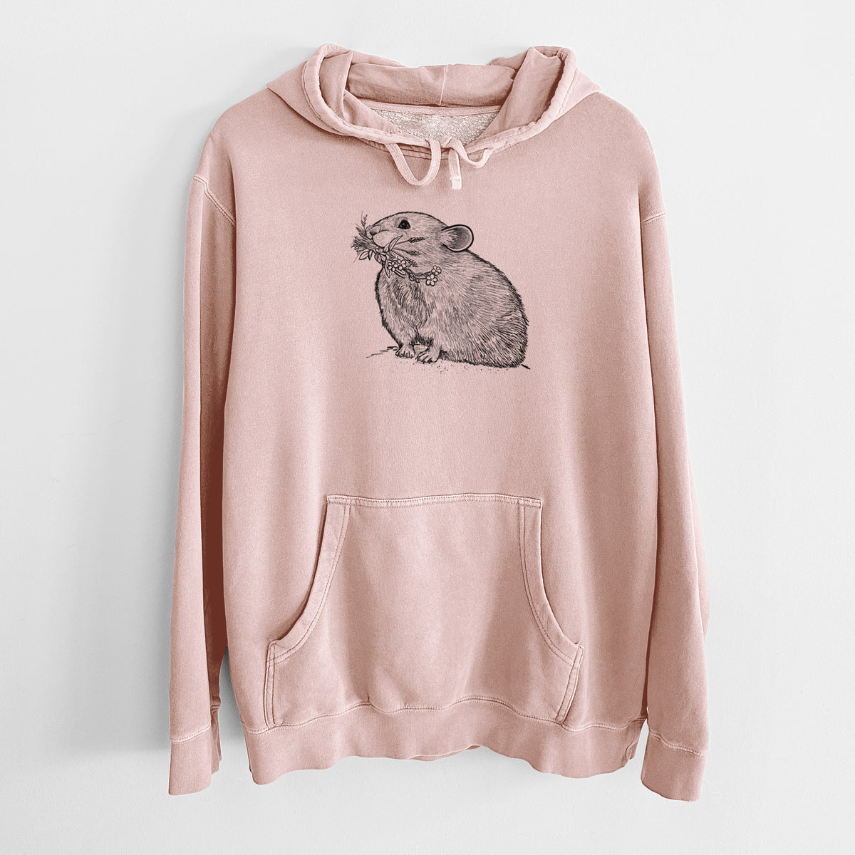 Dusty pink pigment dyed hoodie laid flat, printed with a detailed black ink illustration of an American pika holding flowers and grass in its mouth.