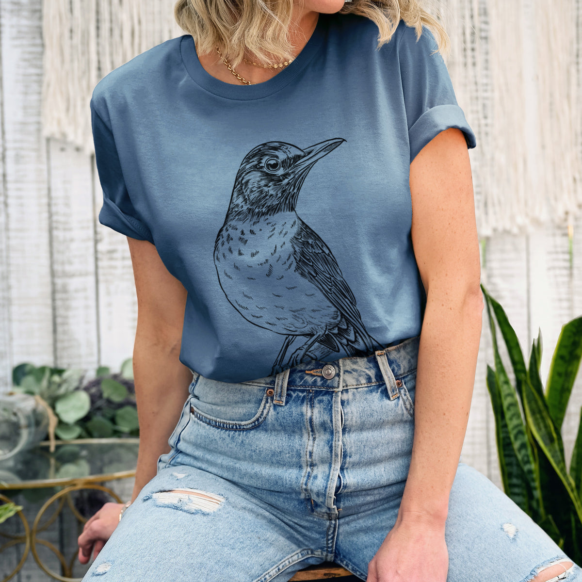 Woman wearing a steel blue lightweight cotton t-shirt printed with a detailed black ink sketch of an American robin perched on a branch.