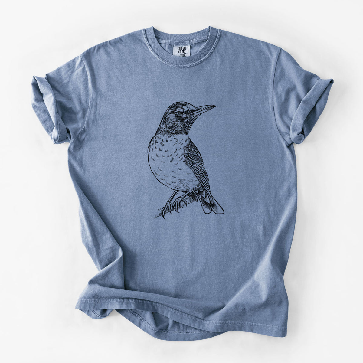 Blue jean Comfort Colors t-shirt laid flat, printed with a detailed black ink sketch of an American robin perched on a branch.
