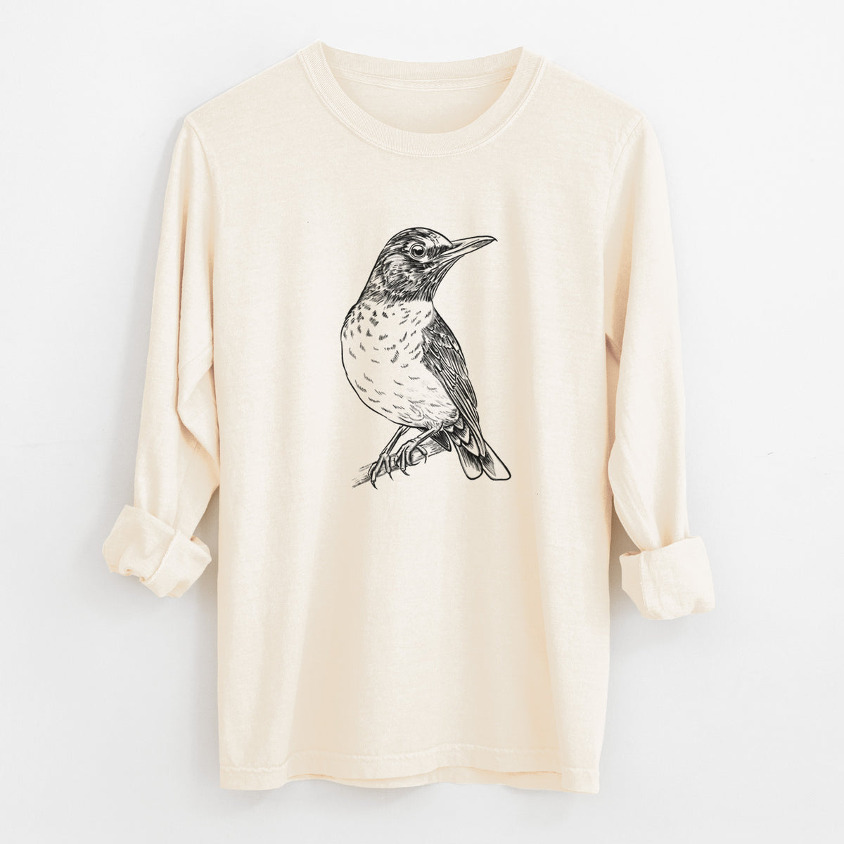 Ivory Comfort Colors long sleeve shirt laid flat with the cuffs rolled, printed with a detailed black ink sketch of an American robin perched on a branch.