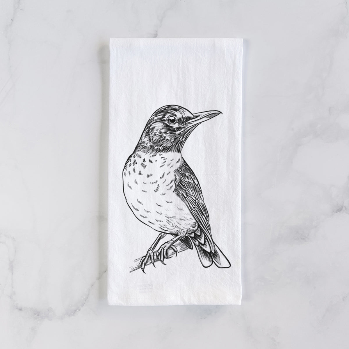 White cotton tea towel laid flat on marble, printed with a detailed black ink sketch of an American robin perched on a branch.