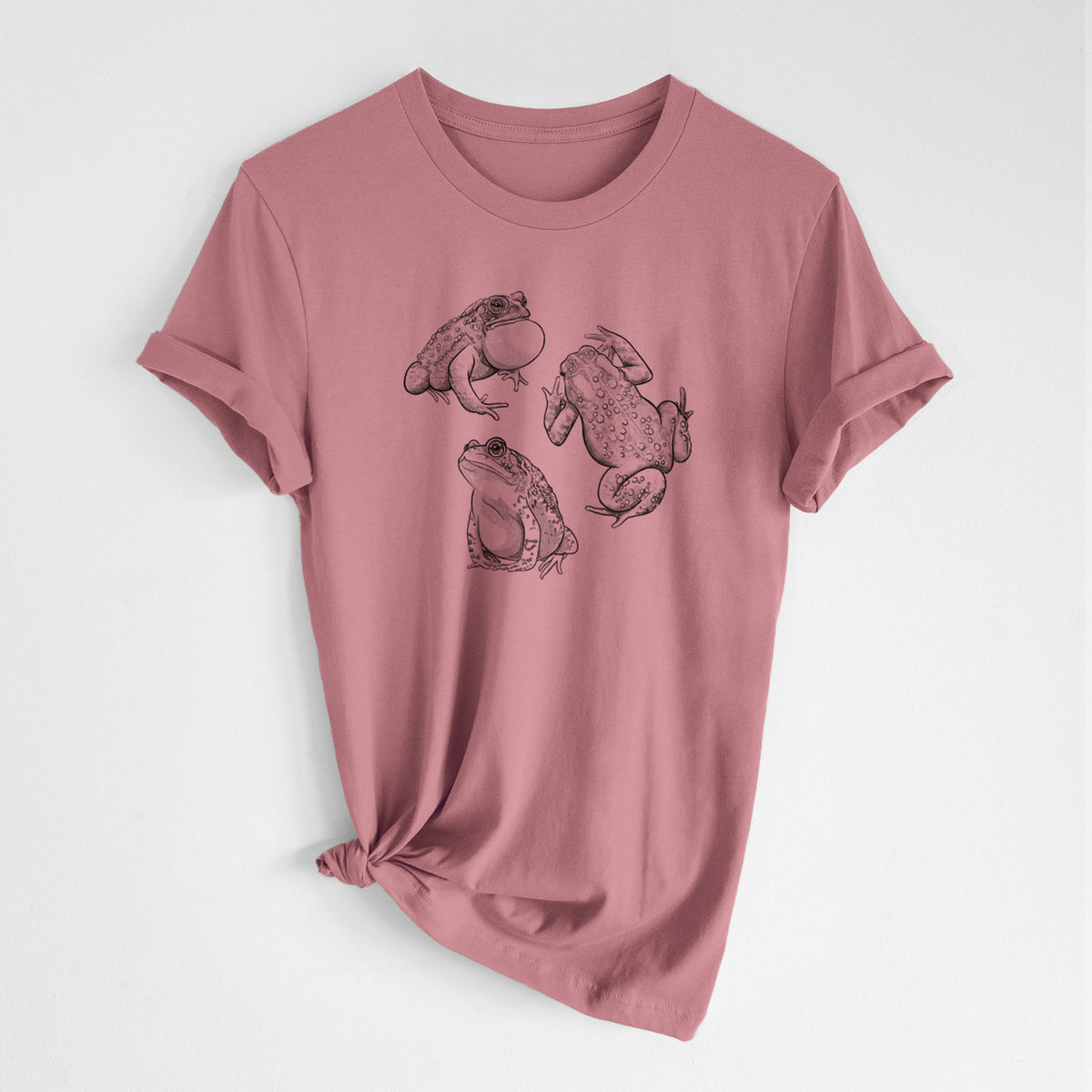 Mauve pink lightweight cotton t-shirt laid flat with the sleeves rolled, printed with a black ink illustration of three American toads.