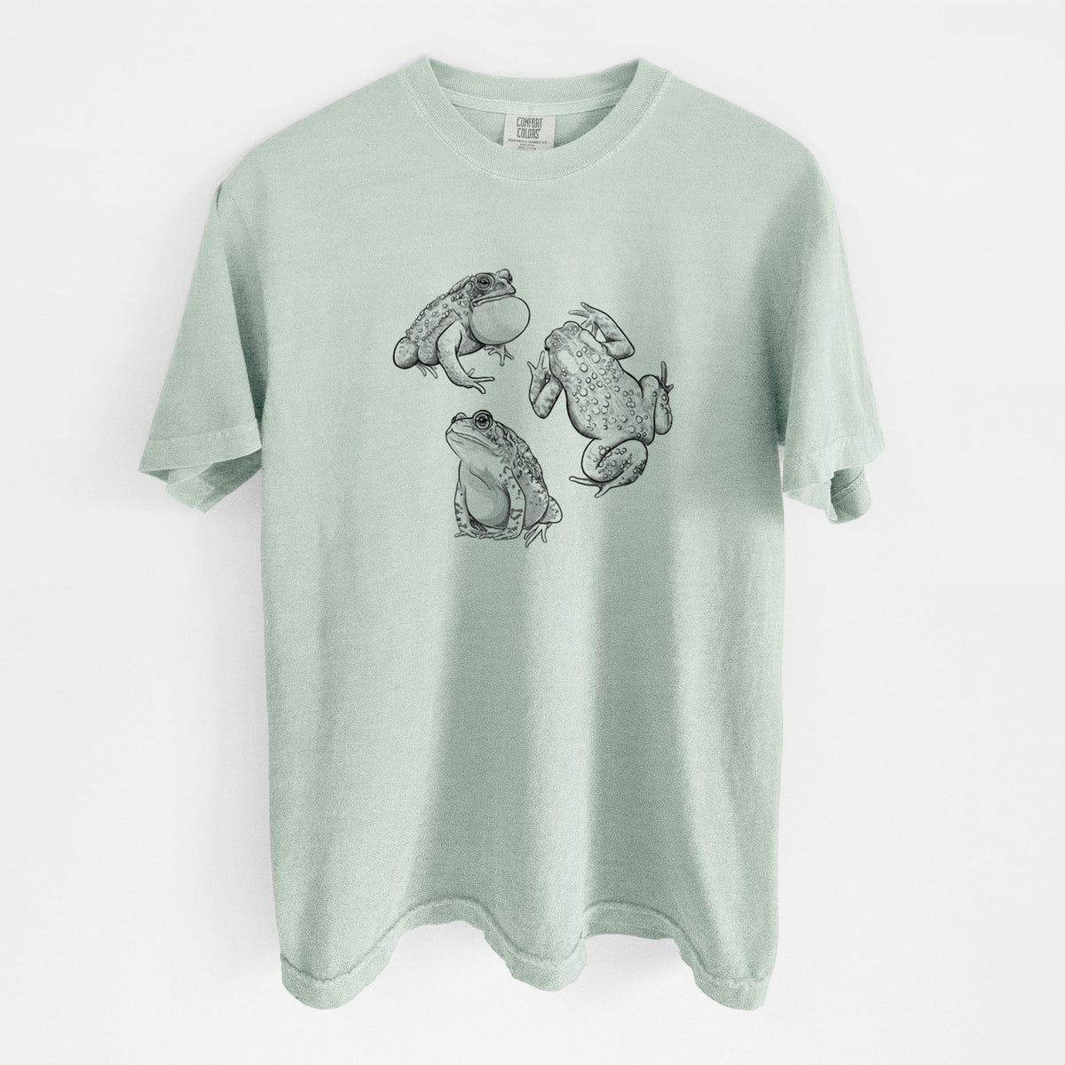 Bay green Comfort Colors t-shirt laid flat, printed with a black ink illustration of three American toads.
