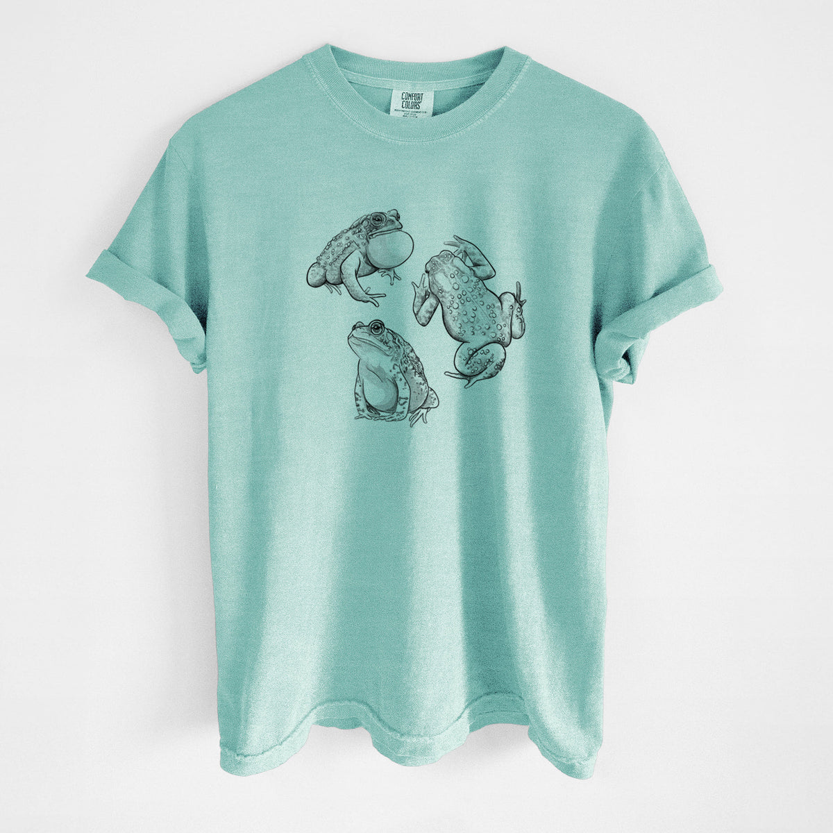 Chalky mint Comfort Colors t-shirt laid flat, printed with a black ink illustration of three American toads.