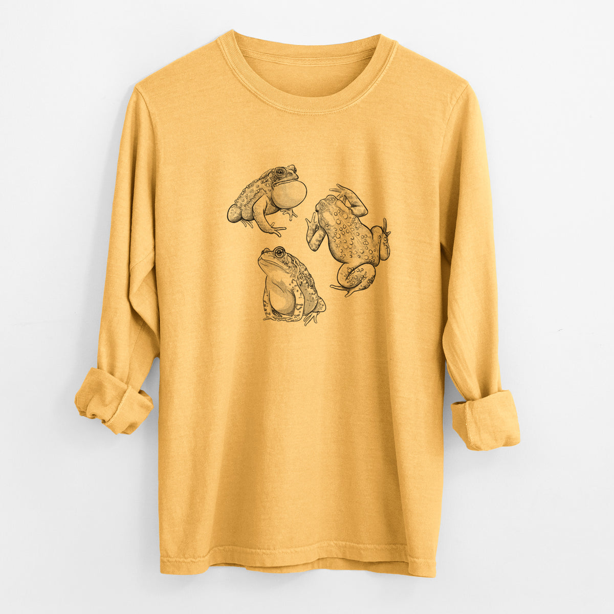 Golden wheat yellow Comfort Colors long sleeve shirt laid flat with the cuffs rolled, printed with a black ink illustration of three American toads.