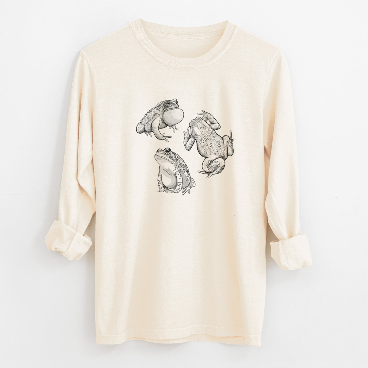 Ivory Comfort Colors long sleeve shirt laid flat with the cuffs rolled, printed with a black ink illustration of three American toads.