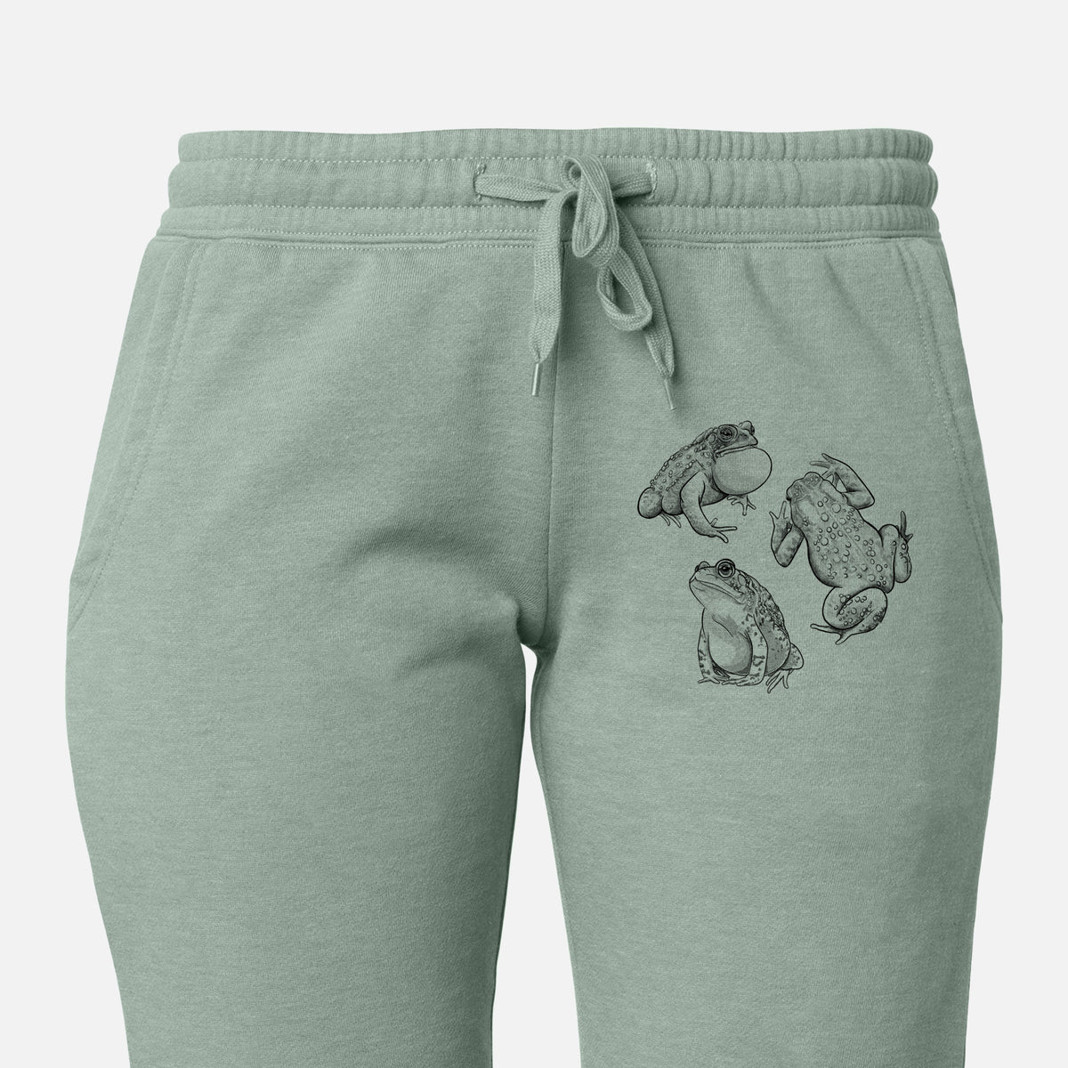 Front of sage green Cali Wave sweatpants, printed with a black ink illustration of three American toads on the leg.