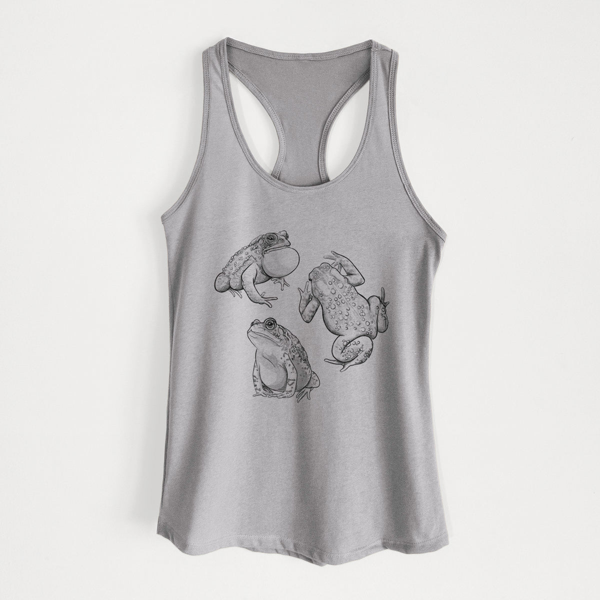 Heather grey women's racerback tank top laid flat, printed with a black ink illustration of three American toads.