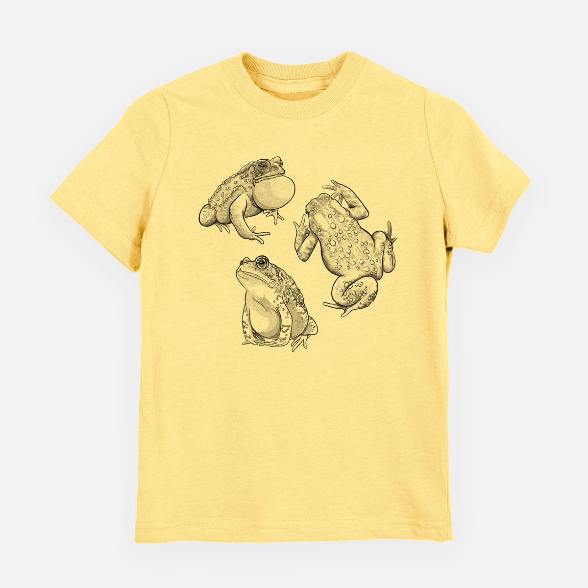 Butter yellow youth t-shirt laid flat, printed with a black ink illustration of three American toads.