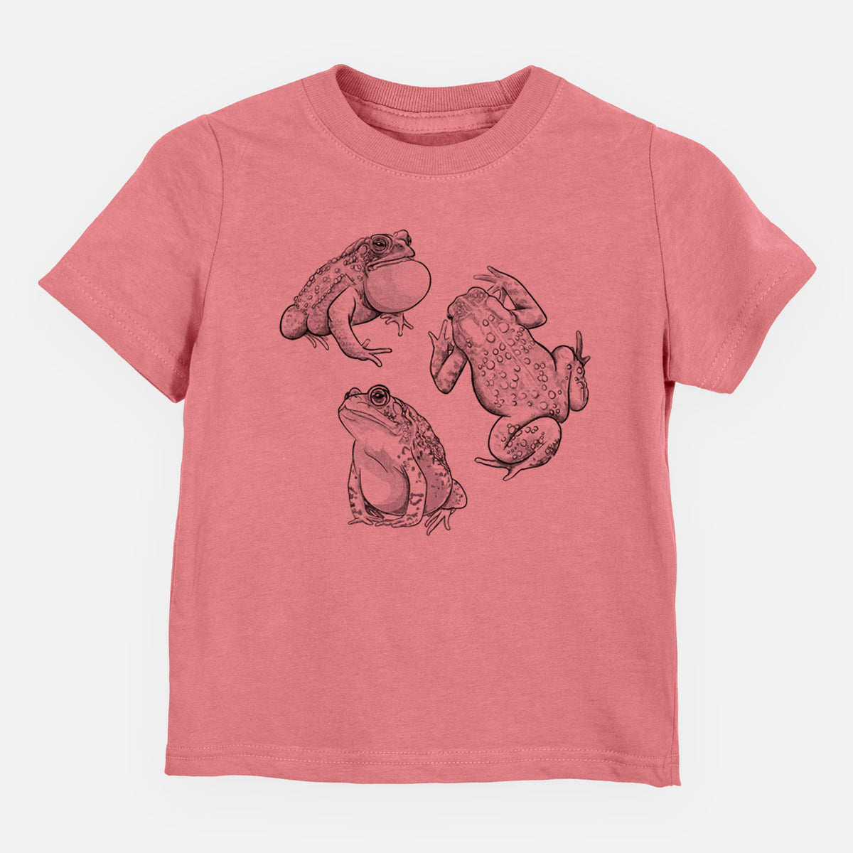 Mauve pink toddler t-shirt laid flat, printed with a black ink illustration of three American toads.