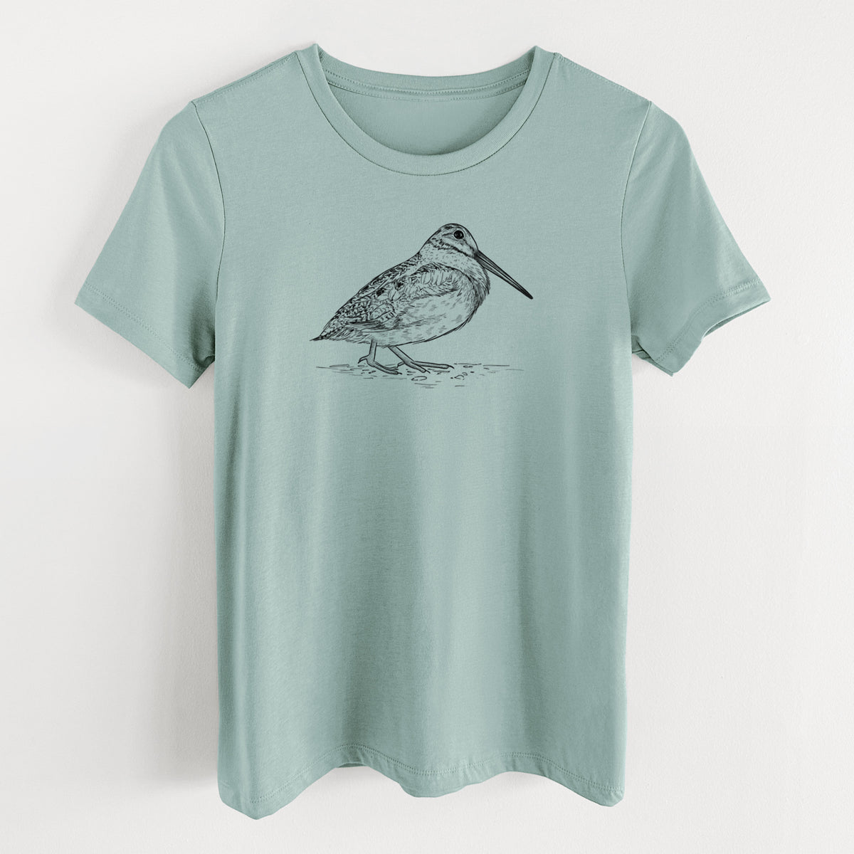 Dusty blue women's relaxed fit cotton t-shirt laid flat, printed with a detailed black ink sketch of an American woodcock standing on the ground.