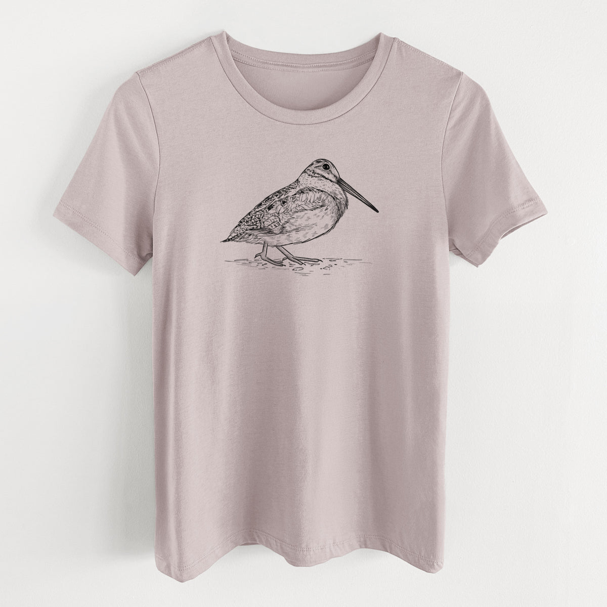 Pink gravel women's relaxed fit cotton t-shirt laid flat, printed with a detailed black ink sketch of an American woodcock standing on the ground.