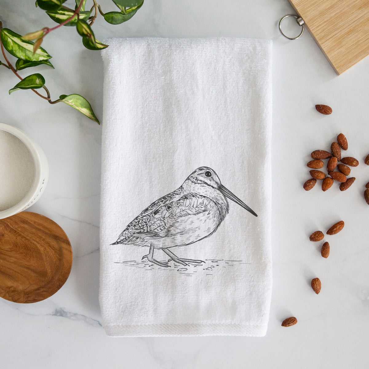 White hand towel printed with a detailed black ink sketch of an American woodcock standing on the ground.