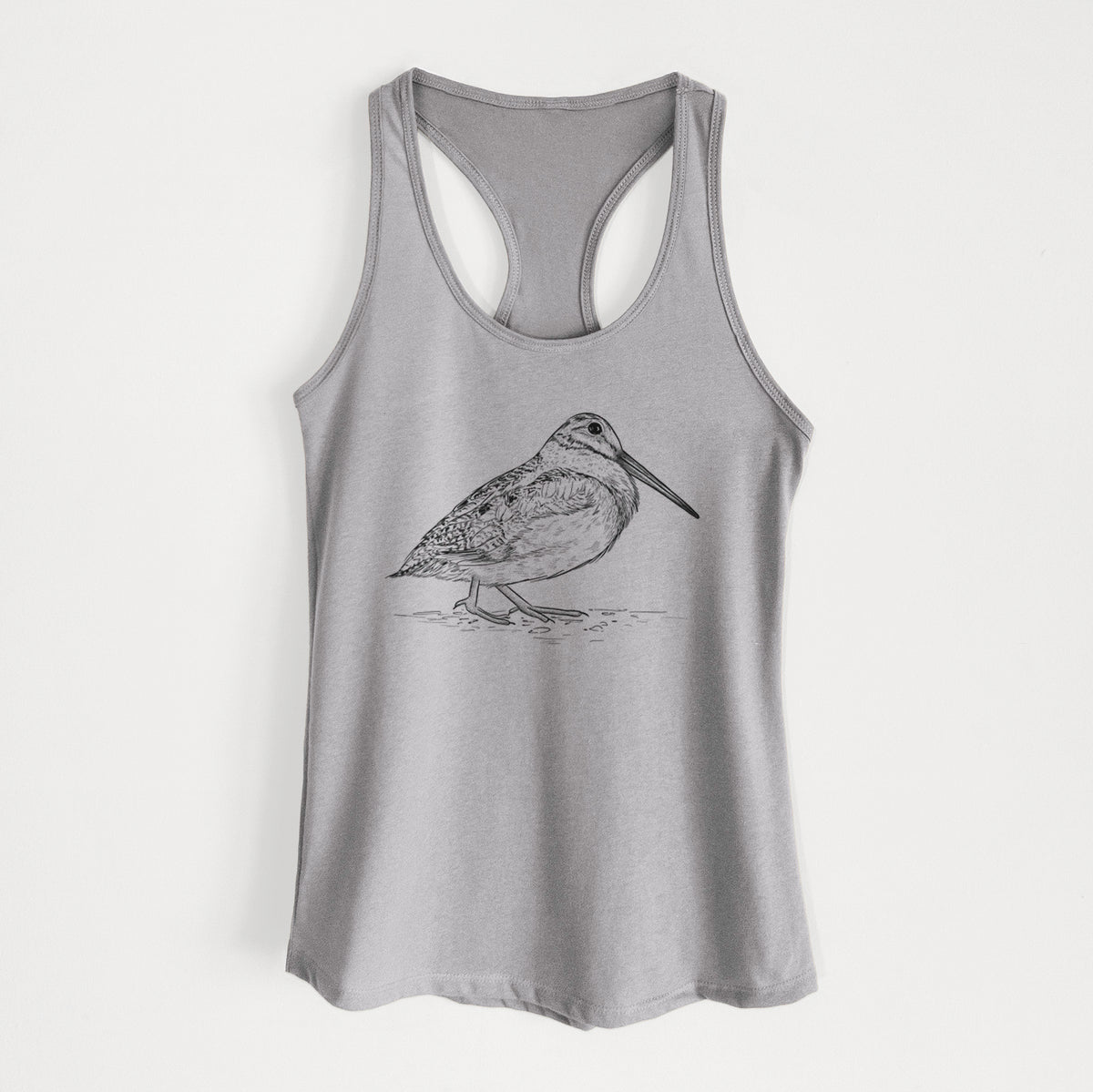 Heather grey women's racerback tank top laid flat, printed with a detailed black ink sketch of an American woodcock standing on the ground.