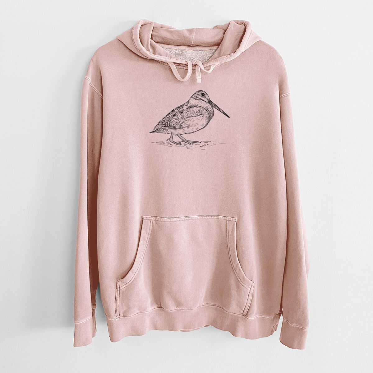 Dusty pink pigment dyed hoodie laid flat, printed with a detailed black ink sketch of an American woodcock standing on the ground.