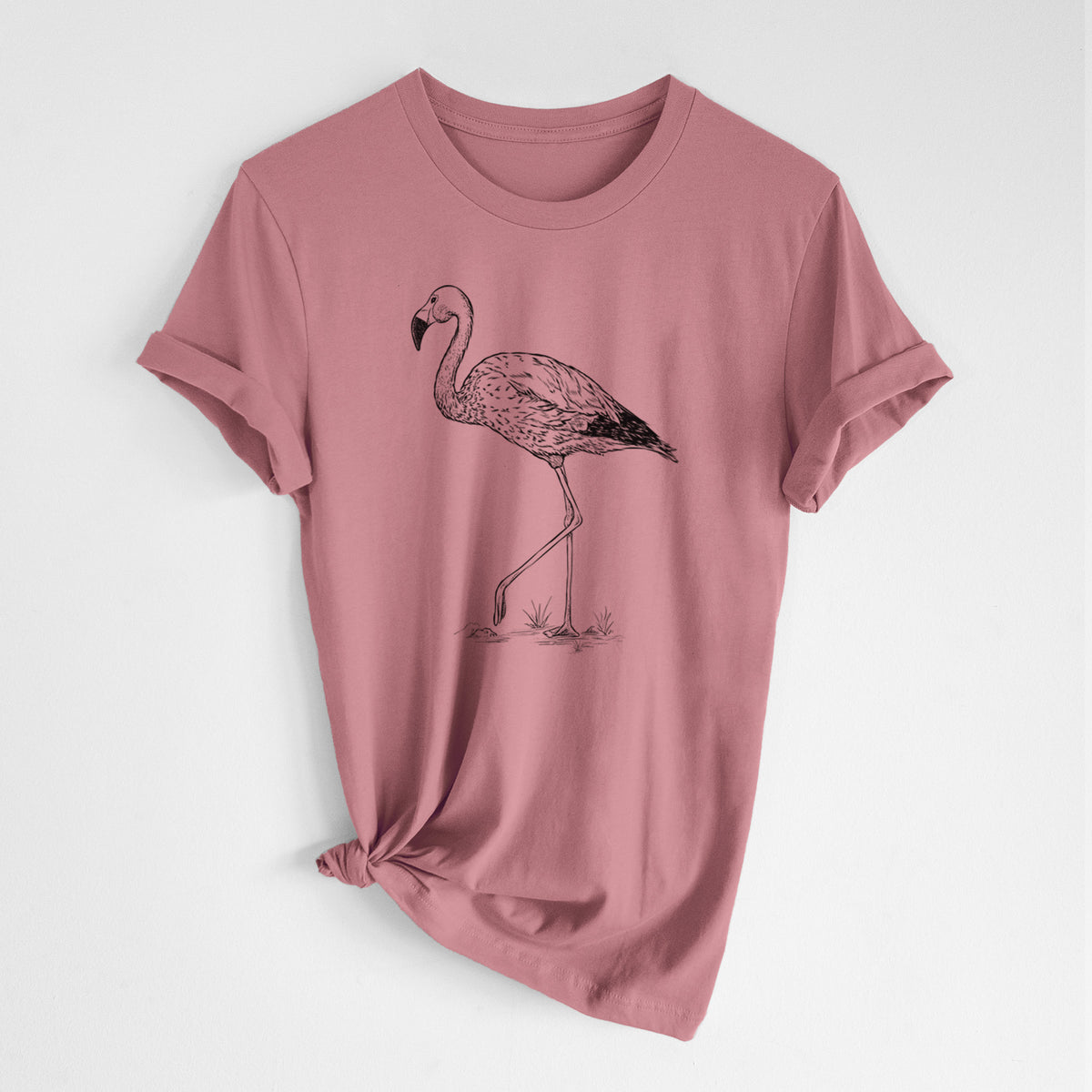 Mauve pink lightweight cotton t-shirt laid flat with the sleeves rolled, printed with a black ink illustration of an Andean flamingo standing on one leg.