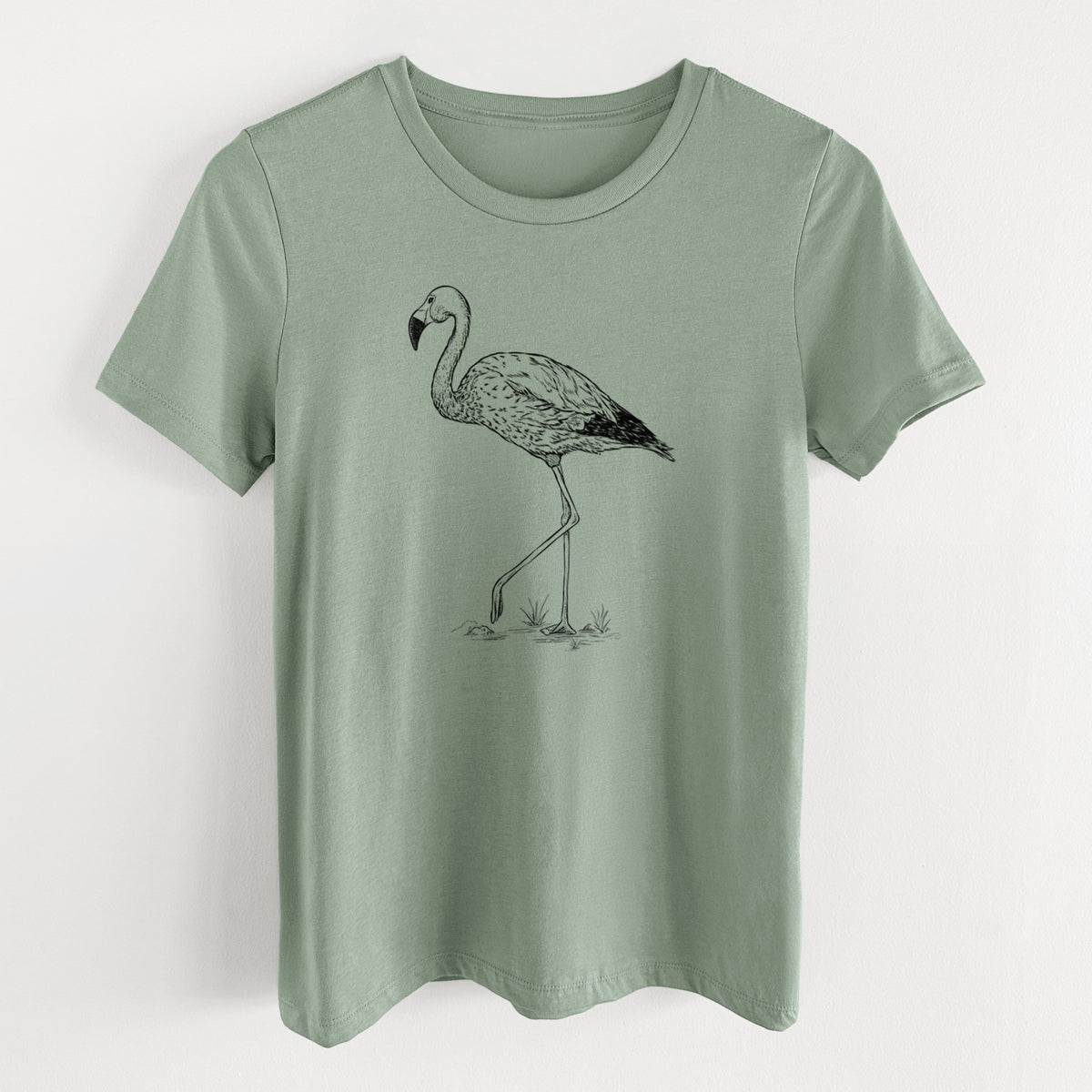Sage green women's relaxed fit cotton t-shirt laid flat, printed with a black ink illustration of an Andean flamingo standing on one leg.