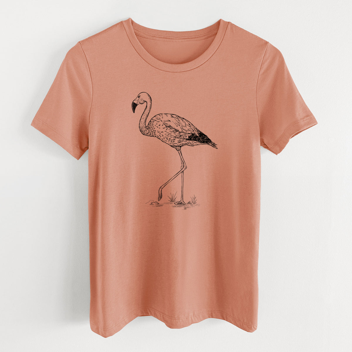Terracotta orange women's relaxed fit cotton t-shirt laid flat, printed with a black ink illustration of an Andean flamingo standing on one leg.